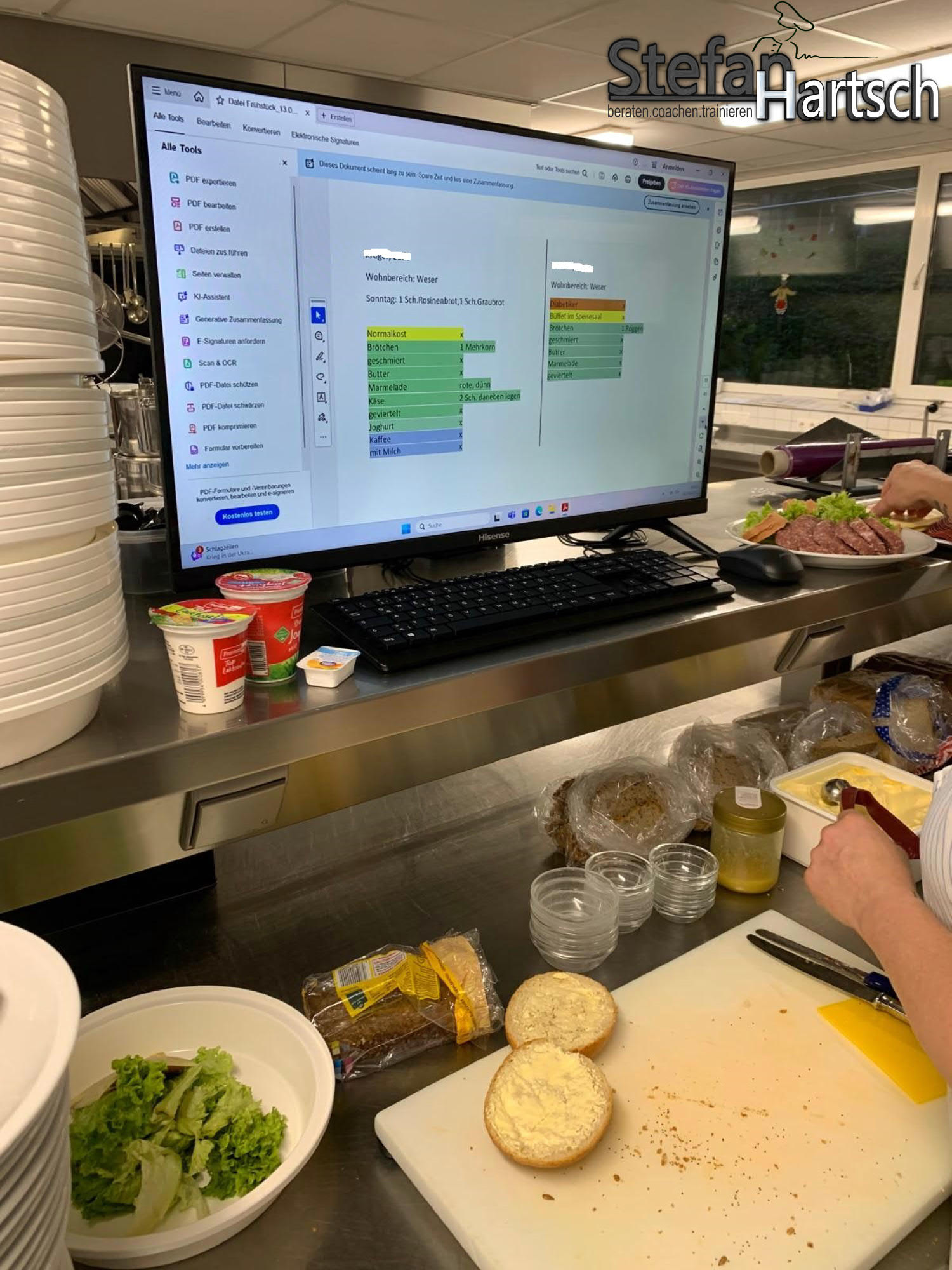 Zwei Mitarbeitende in einer Großküche arbeiten mit digitaler Bewohnerkarte am Bildschirm zur Menüplanung